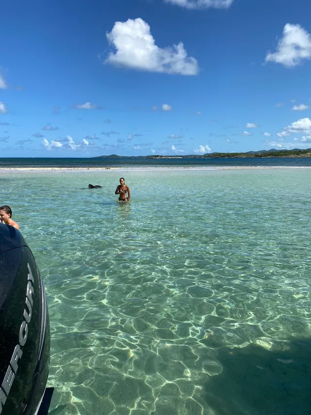 Eau claire et peu profonde, baigneur et sable blanc