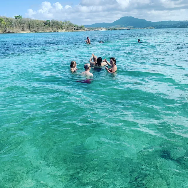 Baigneurs dans l'eau turquoise d'un lagon